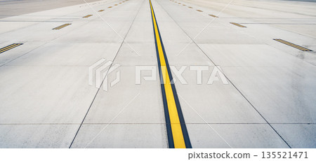 Airport runway. Surface level of long airport runway with yellow marking. Airport runway ready for airplane landing or taking off. Directional sign marking on tarmac of runway at commercial airport 135521471