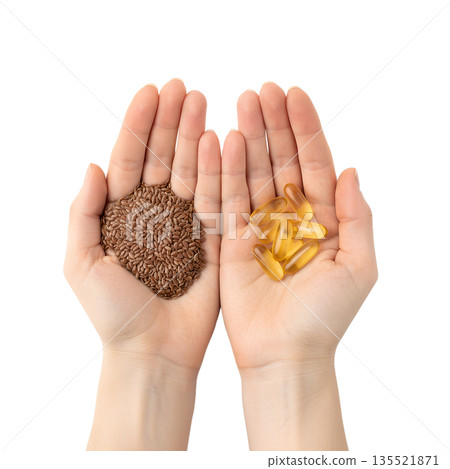 Nutrition comparison, handful of whole flax seeds vs. omega-3 supplement capsules in palms, isolated. For plant-based vs. marine omega-3 sources 135521871
