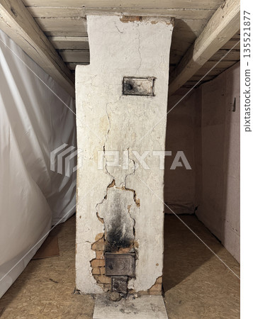 Vintage stove in an old house. The stove is in an emergency condition, cracks and soot marks are visible. 135521877