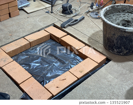 Brickwork of a heating stove base. On waterproofing. Brickwork of a heating stove base. On waterproofing. 135521907