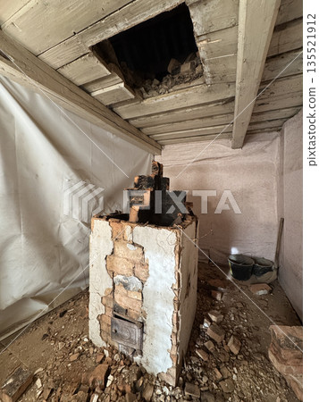 Dismantling a vintage stove in an old house. The firebox door and ash door are visible. The stove is in an emergency condition. 135521912