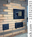 Construction of a heating stove. Doors of the firebox, ash pit, and cleaning channels are visible. Construction of a heating stove. Doors of the firebox, ash pit, and cleaning channels are visible. 135521915