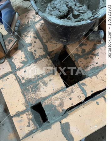 Fresh brickwork of a heating stove. Ash pit of a heating stove. Fresh brickwork of a heating stove. Ash pit of a heating stove. 135521933