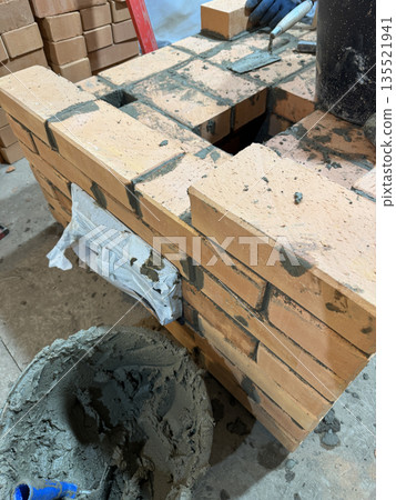 Fresh brickwork of a heating stove. Ash pit of a heating stove. Oblique Angle. Fresh brickwork of a heating stove. Ash pit of a heating stove. Oblique Angle. 135521941