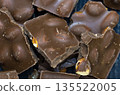 Broken pieces of chocolate. Chocolates with a nut. 135522005