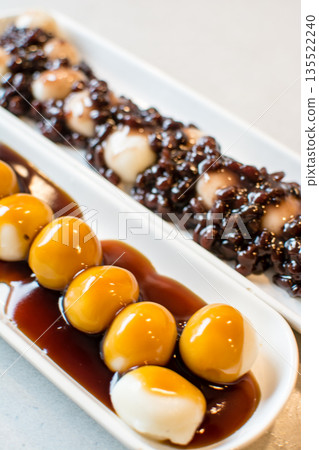 御手洗團子和紅豆沙混合團子整齊地排列在長條形的盤子上。 135522240