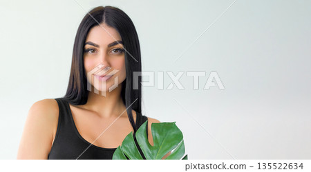 Harmony treatment. Natural charm. Tender young woman with green monstera leaf. Youthful eco care face hair body isolated on white. Harmony treatment. Natural charm. Tender young woman with green monstera leaf. Youthful eco care face hair body isolated on white. 135522634