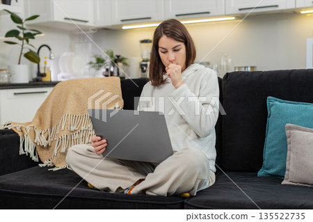 Young woman completes online exam on laptop reads questions selects answers taps Submit feels relief Young woman completes online exam on laptop reads questions selects answers taps Submit feels relief 135522735