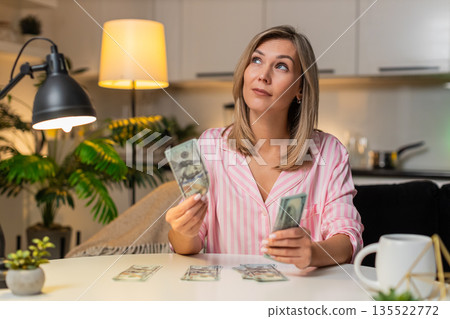 Adult woman counts cash dollars sorts budget piles expenses savings plans family finance night plan 135522772