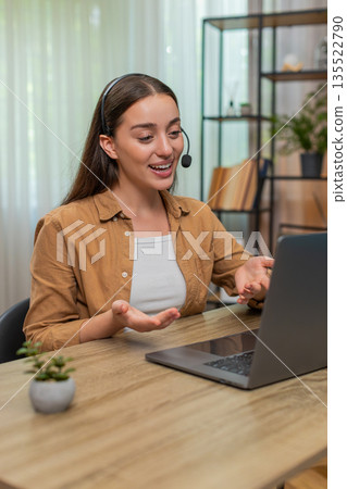 Young woman hosting online conference on laptop speaking in microphone with clear professional style 135522790