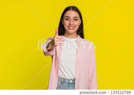 Woman smiling showing thumbs up gesture with confidence approval positivity happy emotional reaction Woman smiling showing thumbs up gesture with confidence approval positivity happy emotional reaction 135522799