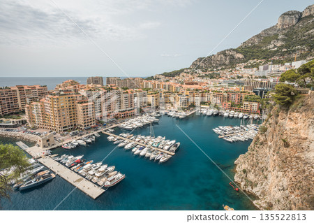 Panoramic view of Monaco harbor with luxury yachts, waterfront buildings and Mediterranean coastline Panoramic view of Monaco harbor with luxury yachts, waterfront buildings and Mediterranean coastline 135522813