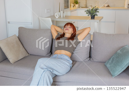 Young woman sits down and relaxes after work slow breath calm mood gentle pause and rest with peace Young woman sits down and relaxes after work slow breath calm mood gentle pause and rest with peace 135522947
