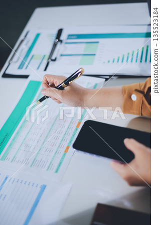 Business woman using calculator to calculate financial report, working at office with laptop computer on table. Asian female accountant or banker making calculations. finances and economy concept Business woman using calculator to calculate financial report, working at office with laptop computer on table. Asian female accountant or banker making calculations. finances and economy concept 135523184
