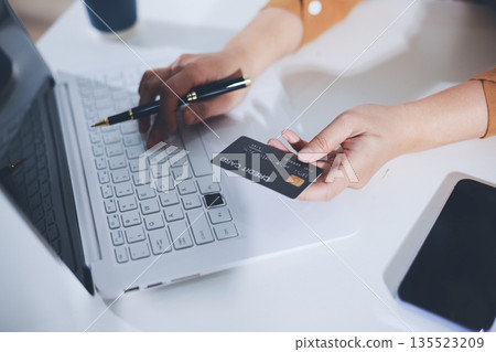 Online payment, Hands of woman holding a credit card and using smart phone for online shopping 135523209