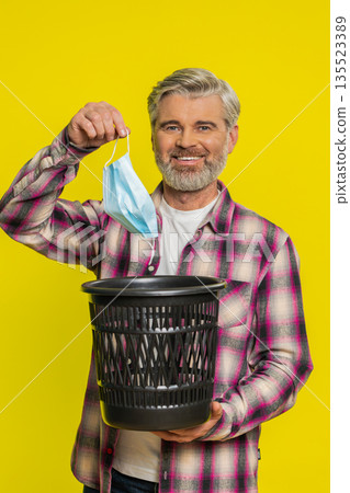 Mature man taking off medical mask flu treatment cure ending of pandemic quarantine disease recover Mature man taking off medical mask flu treatment cure ending of pandemic quarantine disease recover 135523389