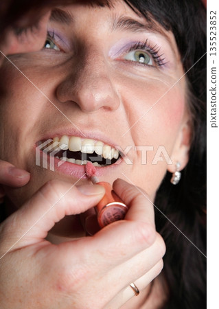 woman paints face with makeup woman paints face with makeup 135523852