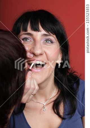 woman paints face with makeup 135523853