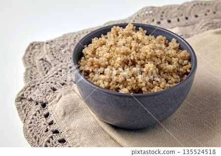cooked quinoa porridge in a gray bowl on a brown linen tablecloth. cooked quinoa porridge in a gray bowl on a brown linen tablecloth. 135524518