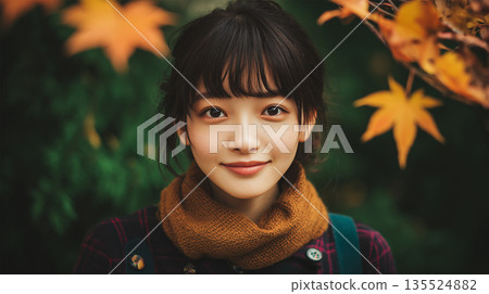 深綠色秋日背景下一位女學生輕輕微笑的畫像 135524882