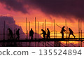 黃昏時分，工人們在建築工地工作 135524894