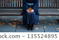 身著日本服飾的秋天，女人坐在長椅上拿著樹葉 135524895