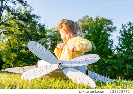 Pretend play child. Girl aviation pilot toy. Summer fun outdoor cardboard. Pretend play child. Girl aviation pilot toy. Summer fun outdoor cardboard. 135525771
