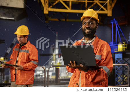 Oil rig platform worker monitoring drilling operations offshore, thinking about risk assessment and efficient natural gas or fossil fuels extraction for the industry. Oil pump and resources. 135526385