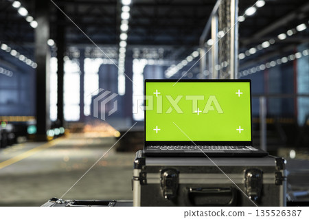 Isolated mockup laptop in empty industrial plant with machinery, fabrication zones and steel components framed by modern infrastructure. Technology integration and design potential. 135526387