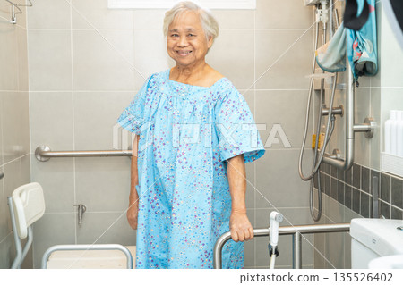 Asian elderly woman patient use toilet bathroom handle security in nursing hospital. Asian elderly woman patient use toilet bathroom handle security in nursing hospital. 135526402