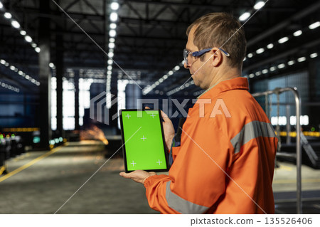 Vertical green screen with personnel in industry plant handling manufacturing process with automation equipment, engineering skills and production accuracy. Heavy industrial operations. 135526406