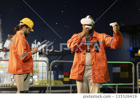 Drilling ship worker doing immersive seabed analysis with virtual reality. African american man on offshore platform visualizing underwater topography through VR gear for precision drilling 135526419