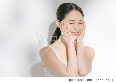 一名年輕女子正在做皮膚護理 一名年輕女子正在做皮膚護理 135526584