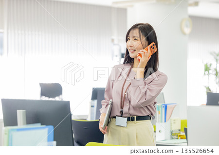 Business woman operating a smartphone Business woman operating a smartphone 135526654
