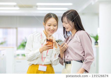 A woman watching a smartphone A woman watching a smartphone 135526674