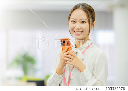 Business woman operating a smartphone Business woman operating a smartphone 135526678
