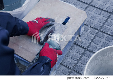 Worker cutting tiles at a construction site 135527052