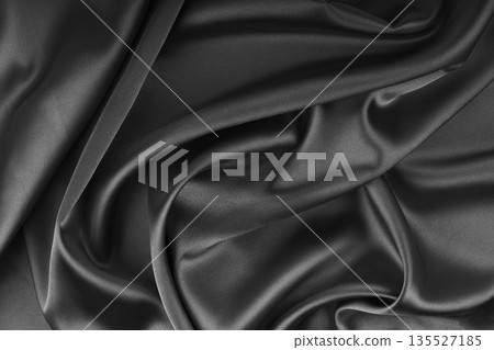 Crumpled, wrinkled black colored glossy silk satin texture. Shiny fabric cloth with wave folds Crumpled, wrinkled black colored glossy silk satin texture. Shiny fabric cloth with wave folds 135527185