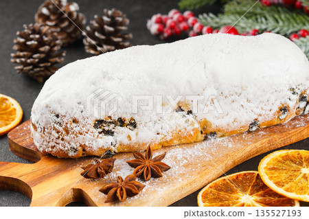 Traditional Christmas Stollen, sweet fruit loaf with sugar icing on wooden board and festive decor Traditional Christmas Stollen, sweet fruit loaf with sugar icing on wooden board and festive decor 135527193