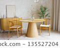 Minimal wooden dining room with round table, bouquet of dried flowers and chairs in modern interior 135527204