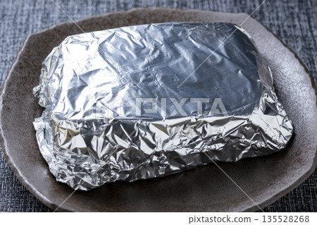 Roast beef cooking scene. Wrapped in aluminum foil to keep warm. 135528268