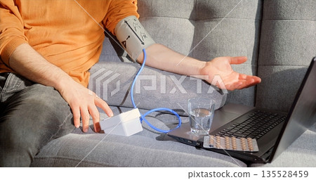 Checking Blood Pressure Comfortably At Home, Relaxed Individual Monitoring Vital Signs Using Digital Tools Checking Blood Pressure Comfortably At Home, Relaxed Individual Monitoring Vital Signs Using Digital Tools 135528459