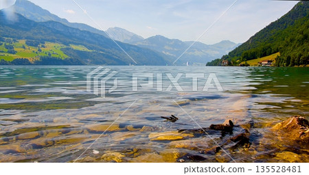 Tranquil Alpine Water Scene, Calm Reflective Lake With Lush Greenery And Distant Mountain Summits Tranquil Alpine Water Scene, Calm Reflective Lake With Lush Greenery And Distant Mountain Summits 135528481