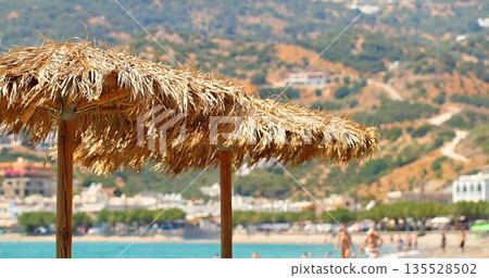Relaxing Coastal Scene With Parasol, Tranquil Beachfront Setting With Vibrant Sky And Distant Resorts Relaxing Coastal Scene With Parasol, Tranquil Beachfront Setting With Vibrant Sky And Distant Resorts 135528502