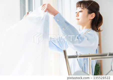 A woman hanging up the laundry 135528522