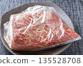 烤牛肉烹飪場景。牛肉塊和調味料放入塑膠袋中醃製。 135528708