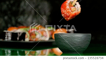 Dipping Salmon Sushi Into Soy Sauce Bowl, Closeup Scene Of Dipping Salmon Roll Into Soy Sauce Bowl 135528734