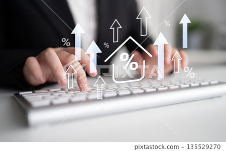 Businessman Typing on Keyboard with Financial Growth Concept, Graph Arrows and Percentage Symbol Overlay in Modern Office Setting Gantry 135529270