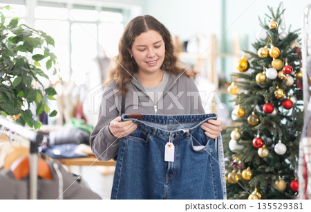 Girl at trading floor pick out jeans, X mas shopping Girl at trading floor pick out jeans, X mas shopping 135529381