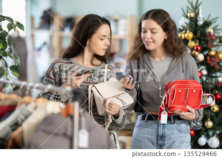 Two young women scanning qr code for handbag Two young women scanning qr code for handbag 135529466